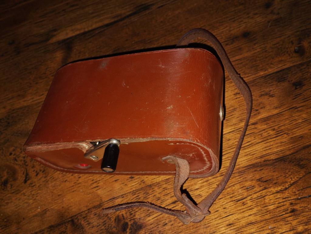 Closed brown leather carrying case with the Gossen ISOGNOM hand crank protruding through the side and visible wear to the strap.
