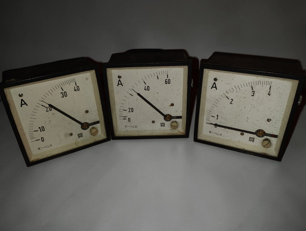 Three vintage EAW Berlin-Treptow AC ammeters with pale dials, black pointers and dark square frames, front view
