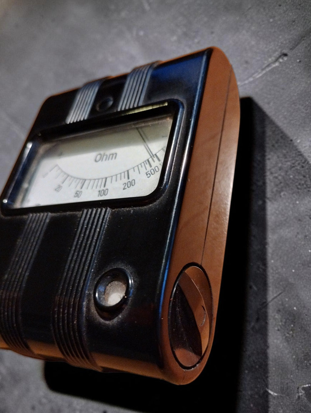 Side view of a vintage bakelite Gossen ohmmeter showing the analog ohm dial
