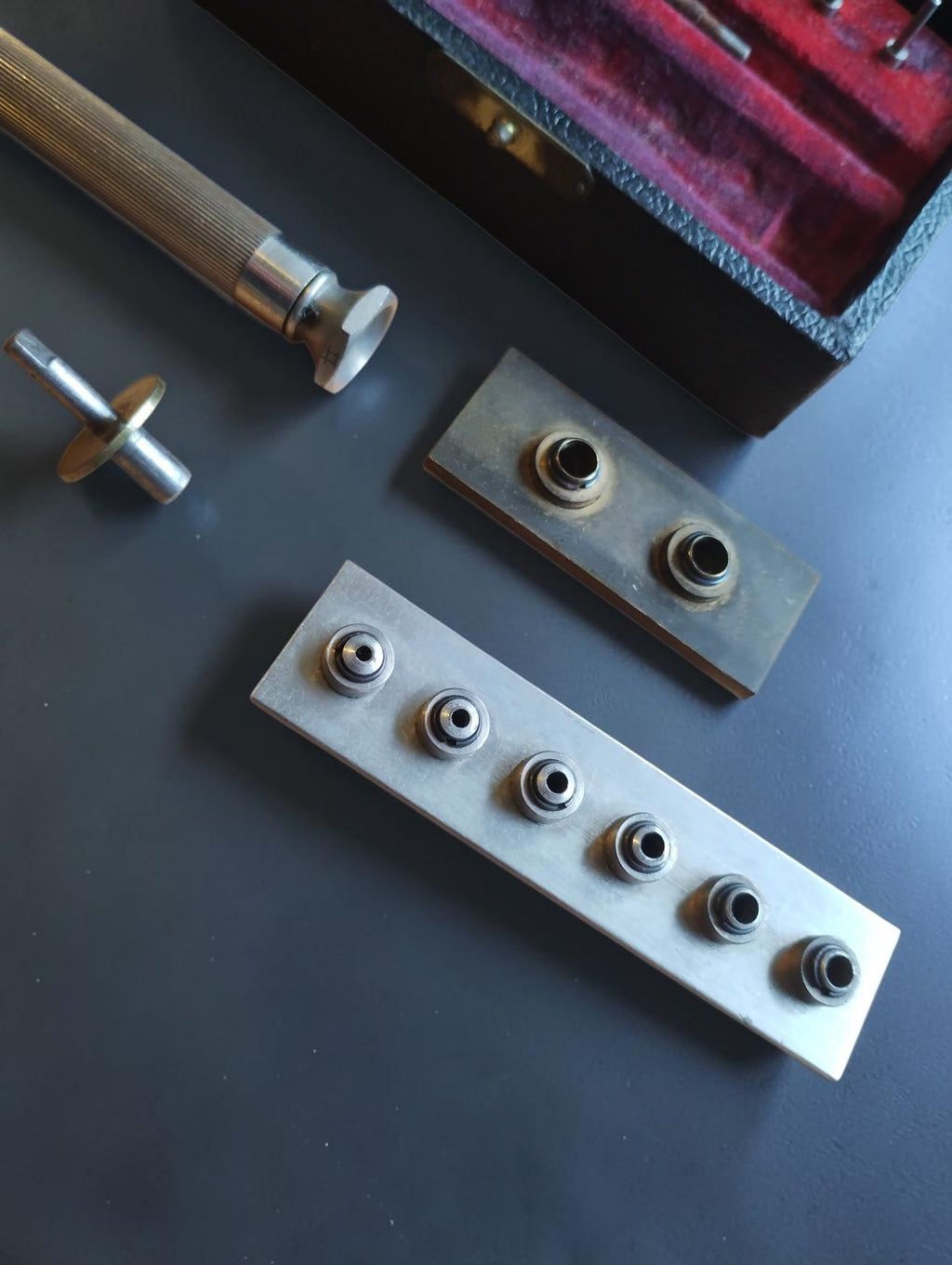 Close-up of interchangeable mainspring winder drums mounted on two metal holders
