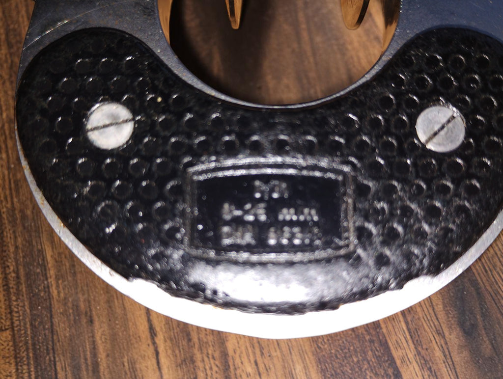 Detail of the Steinmeyer micrometer frame showing the identification plate, screws and surface wear
