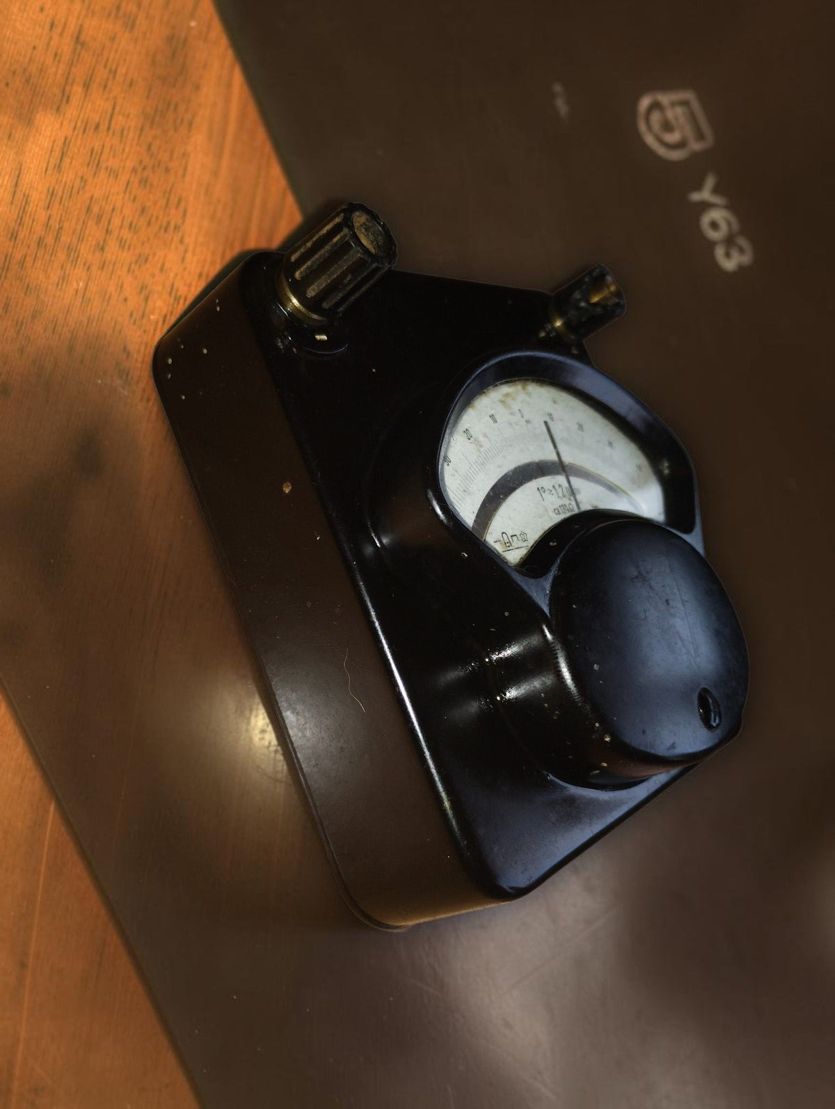 Angled front view of the vintage microammeter, showing its sloping Bakelite case and connection terminals.
