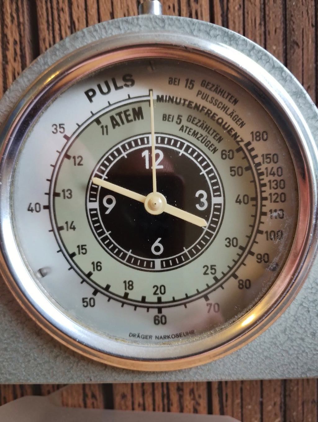Dräger Narkoseuhr dial showing the central clock, pulse scale, respiration scale, and German inscriptions
