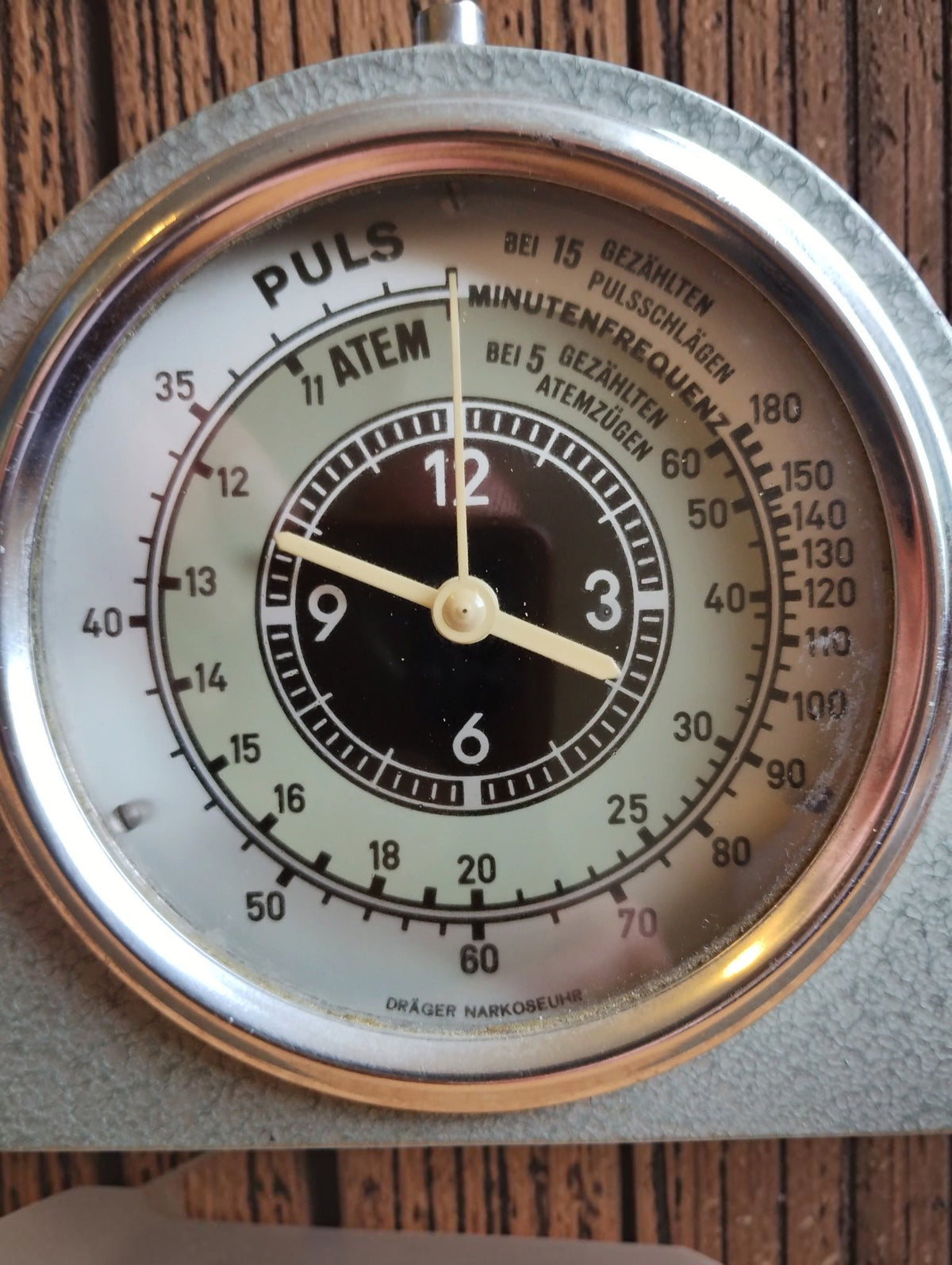 Dräger Narkoseuhr dial showing the central clock, pulse scale, respiration scale, and German inscriptions
