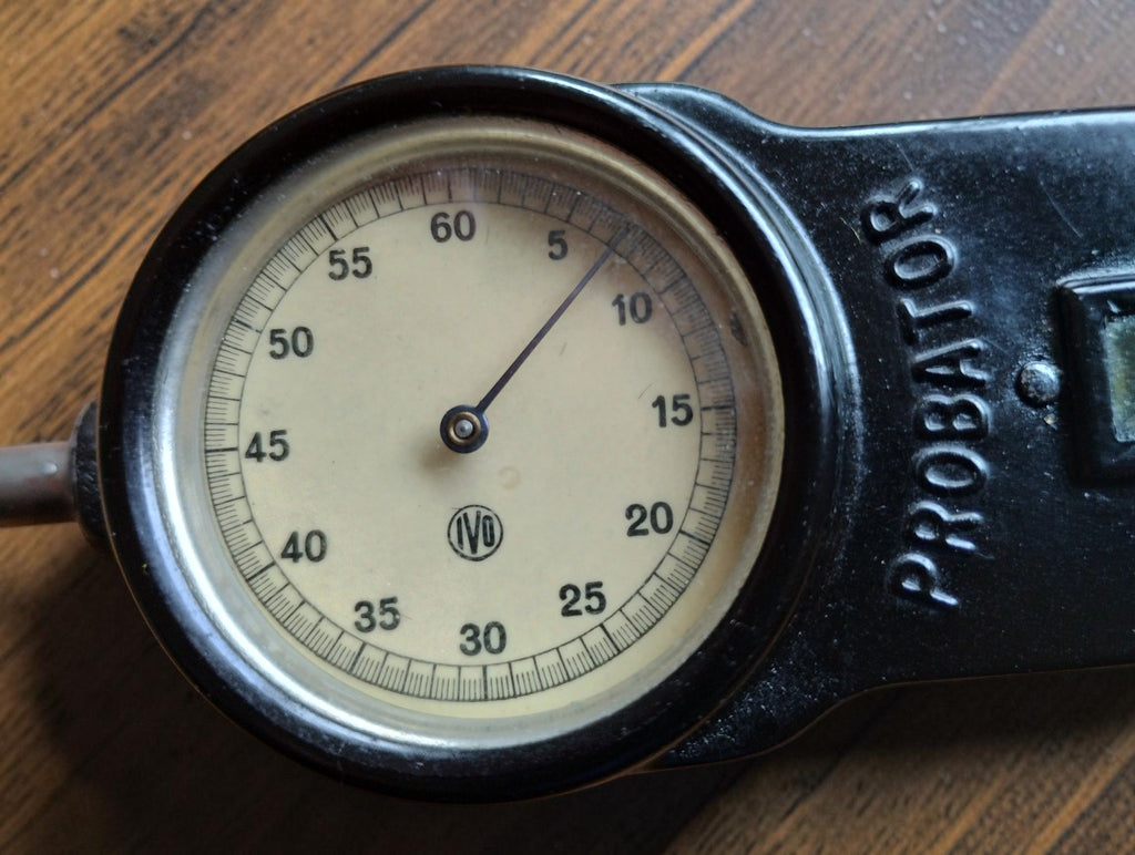 Close-up of the vintage IVO Probator tachometer dial with cream-colored face, numbered scale and IVO logo
