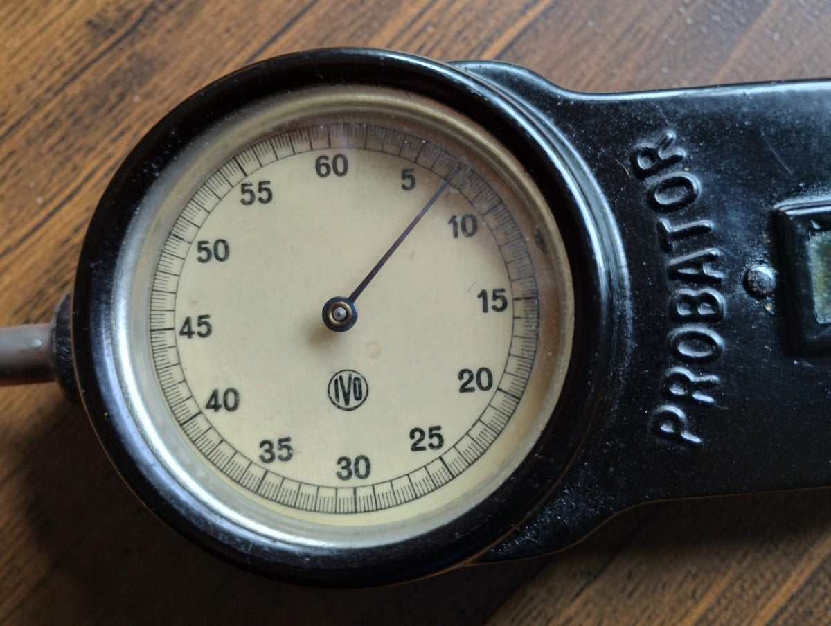 Close-up of the vintage IVO Probator tachometer dial with cream-colored face, numbered scale and IVO logo
