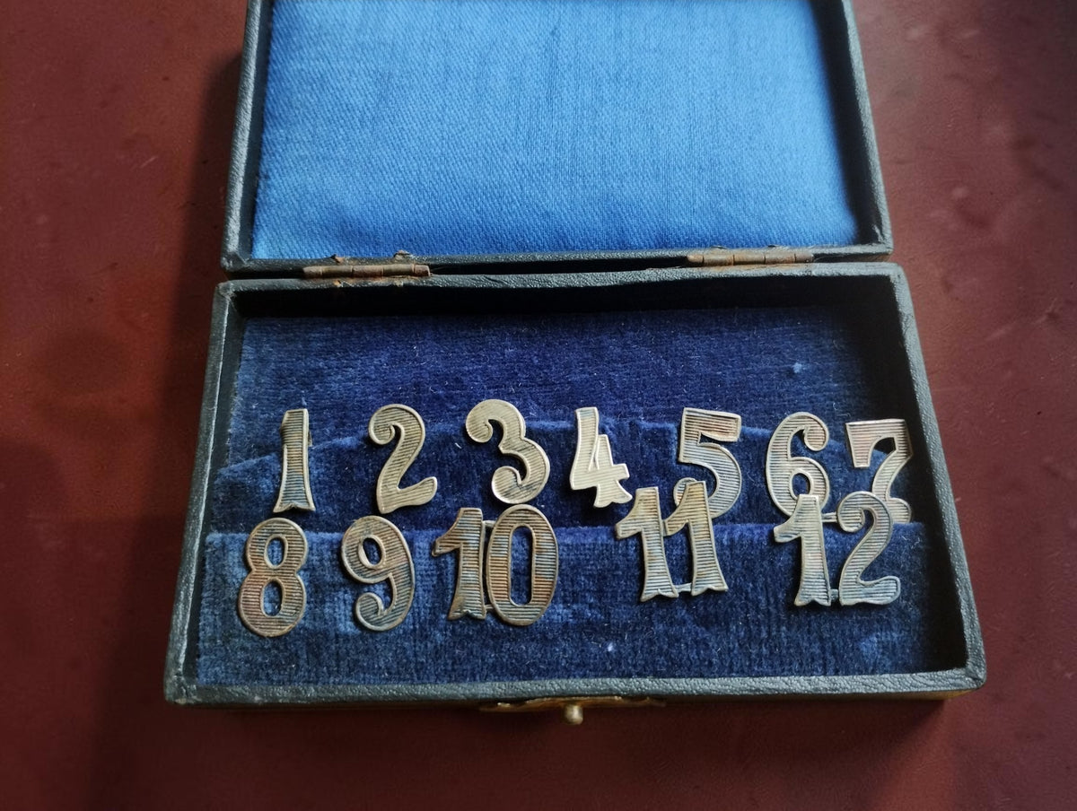 Complete vintage set of metal clock dial numerals 1–12 in a blue velvet-lined box, with 17 mm tall numerals.

