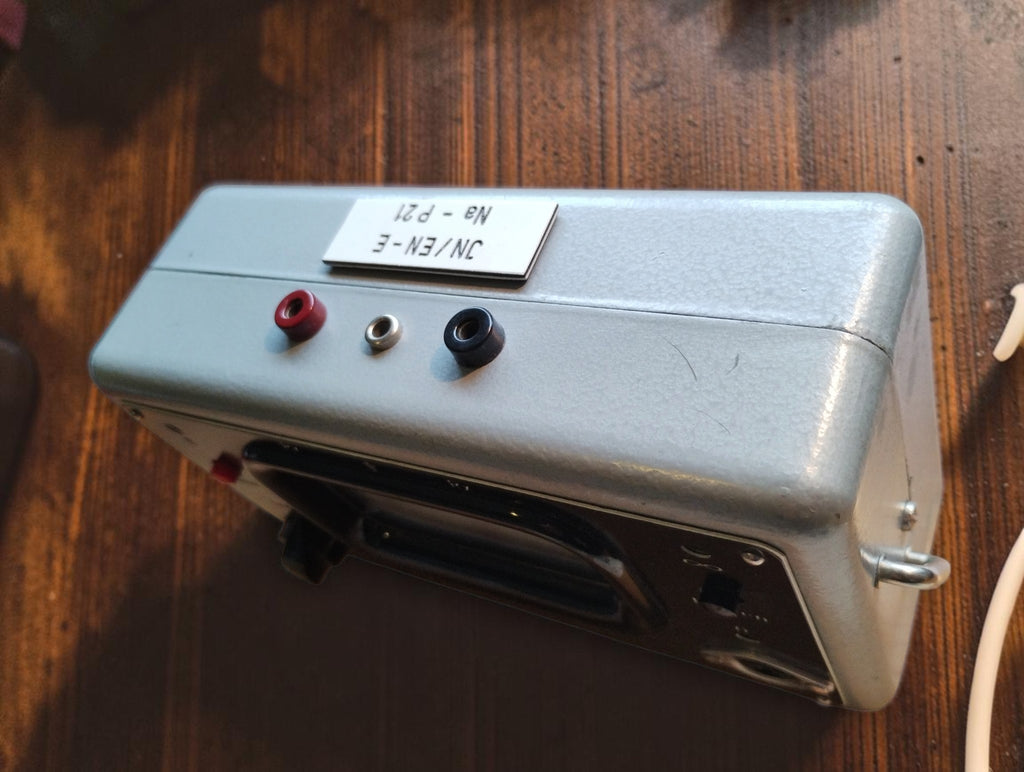 Top view of the RESITEST contact tester showing three terminals, metal housing and identification plate
