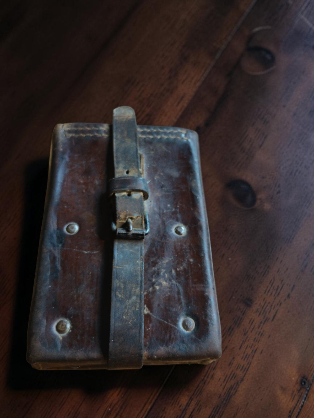 Closed brown leather case for the Siemens & Halske battery tester, with fastening strap, buckle and visible wear.
