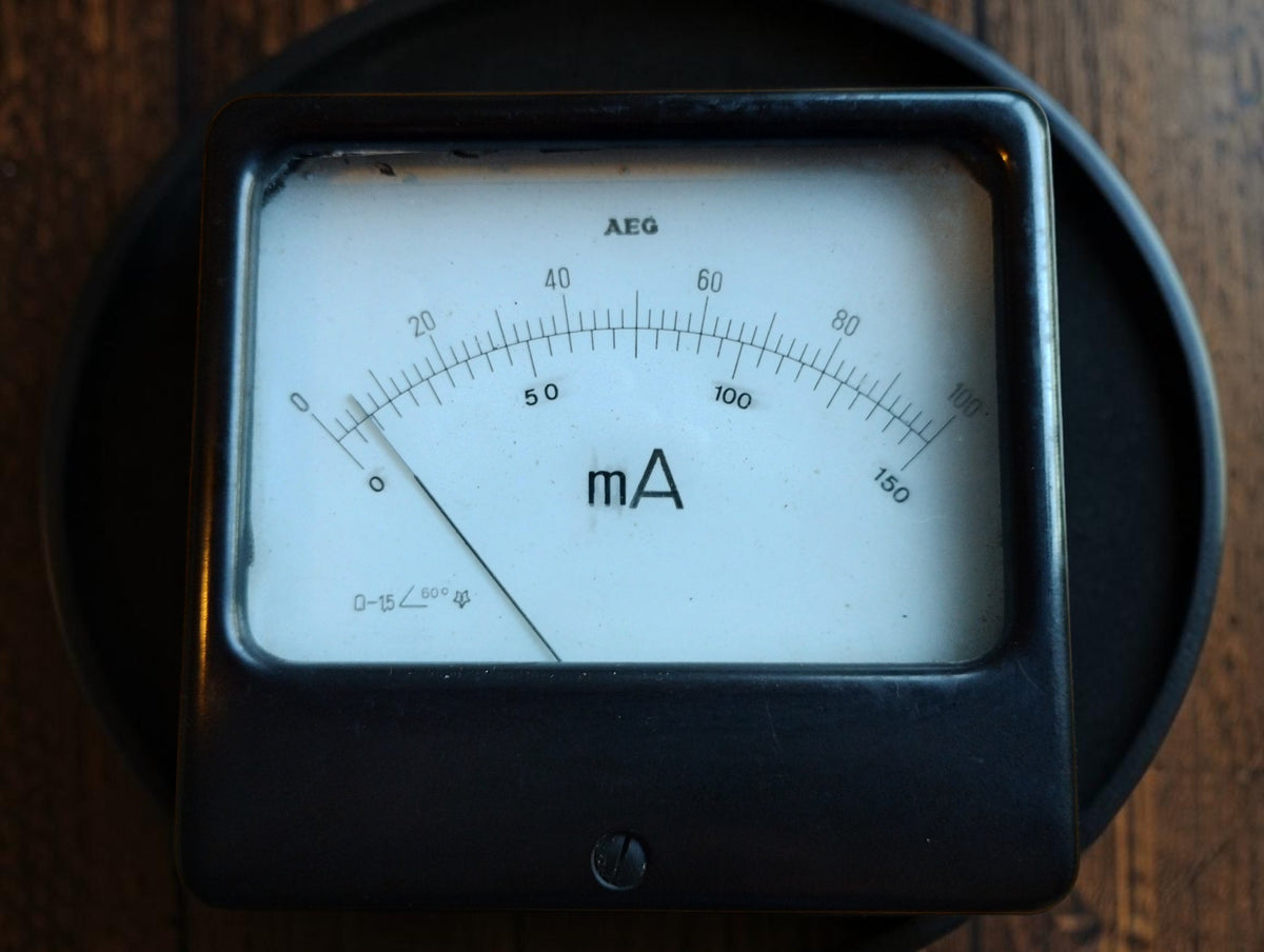Vintage AEG square milliamp meter with dual scales up to 100 and 150 and a black panel-mount housing.
