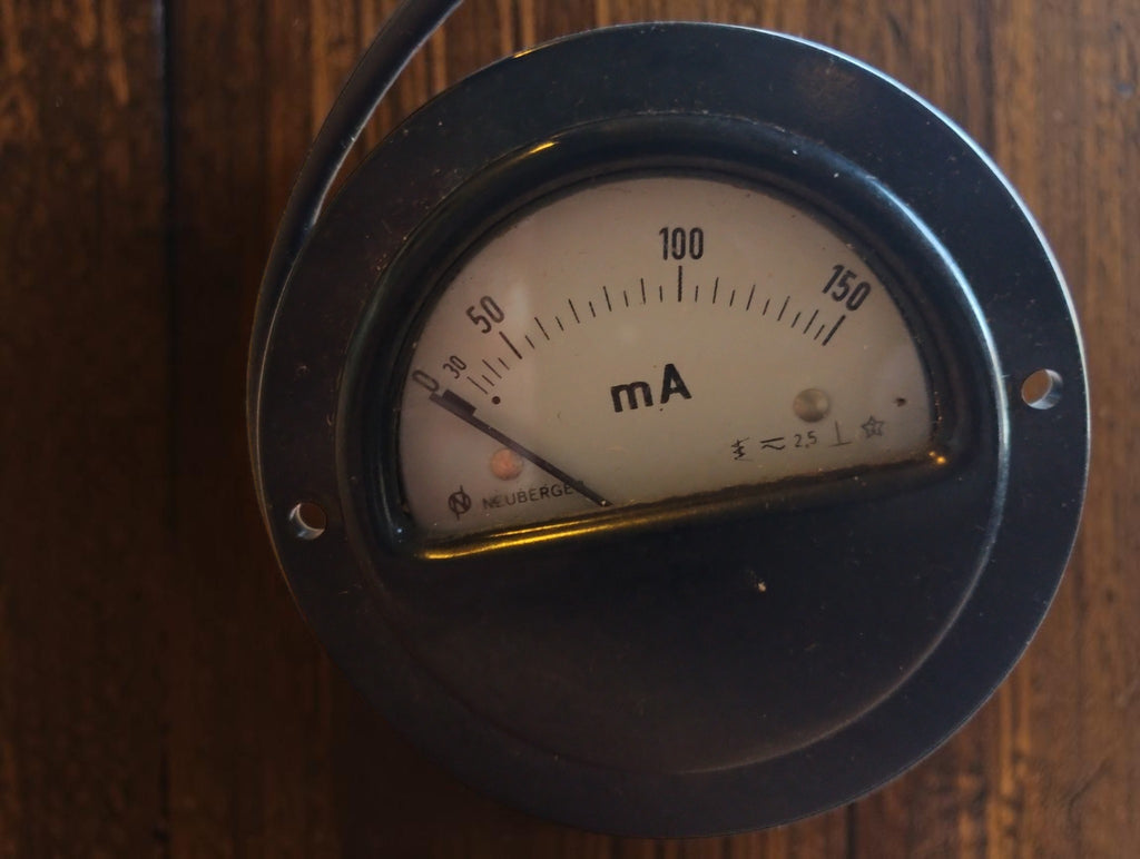 Vintage round milliamp meter with a 0–150 mA scale, cream dial and black mounting flange.
