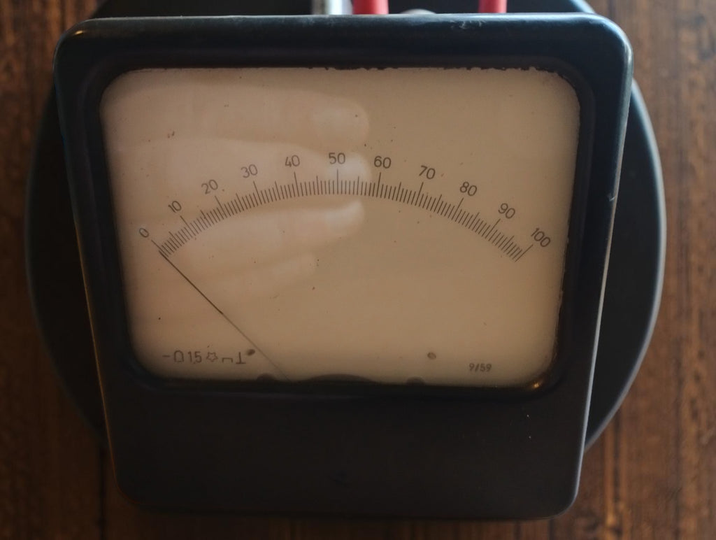 Vintage square analog panel meter with a 0–100 scale, aged cream dial and black housing.
