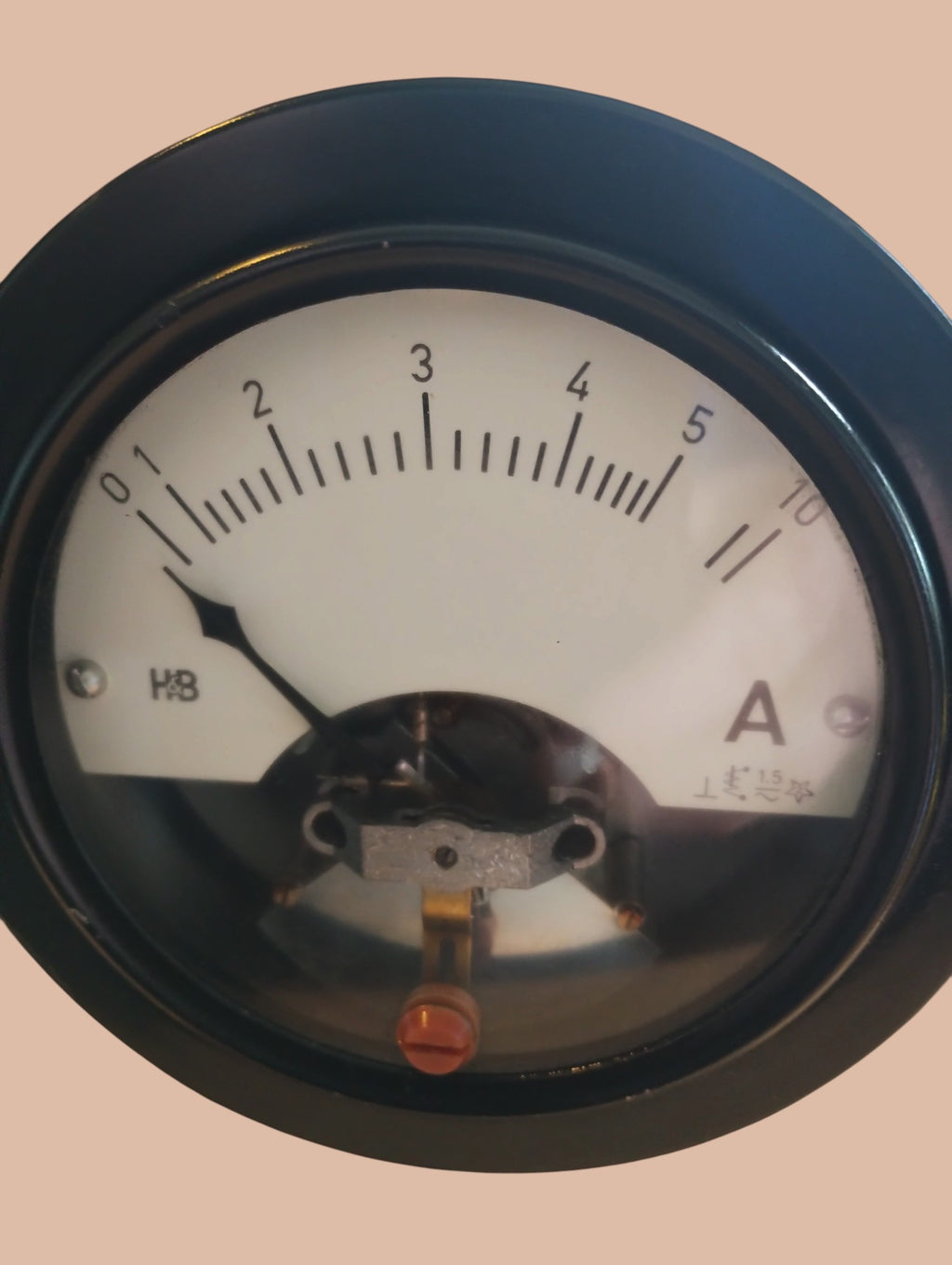 Hartmann & Braun H&B demonstration ammeter with black circular housing on a wooden panel, angled side view
