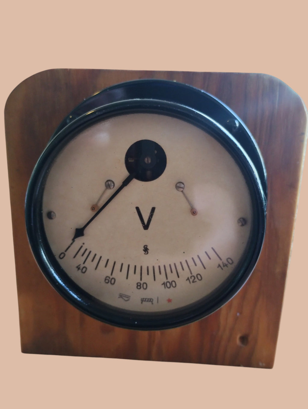 Close-up of the vintage AC voltmeter dial with a 0–140 V scale, pointer, and black metal bezel.
