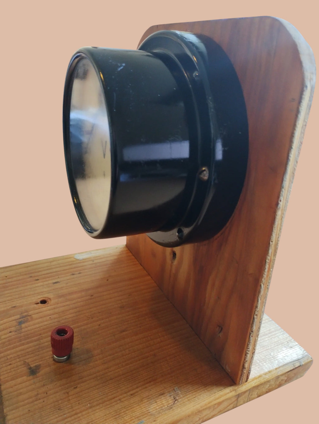 Side view of the analog AC voltmeter showing its deep black housing and wooden mounting stand.

