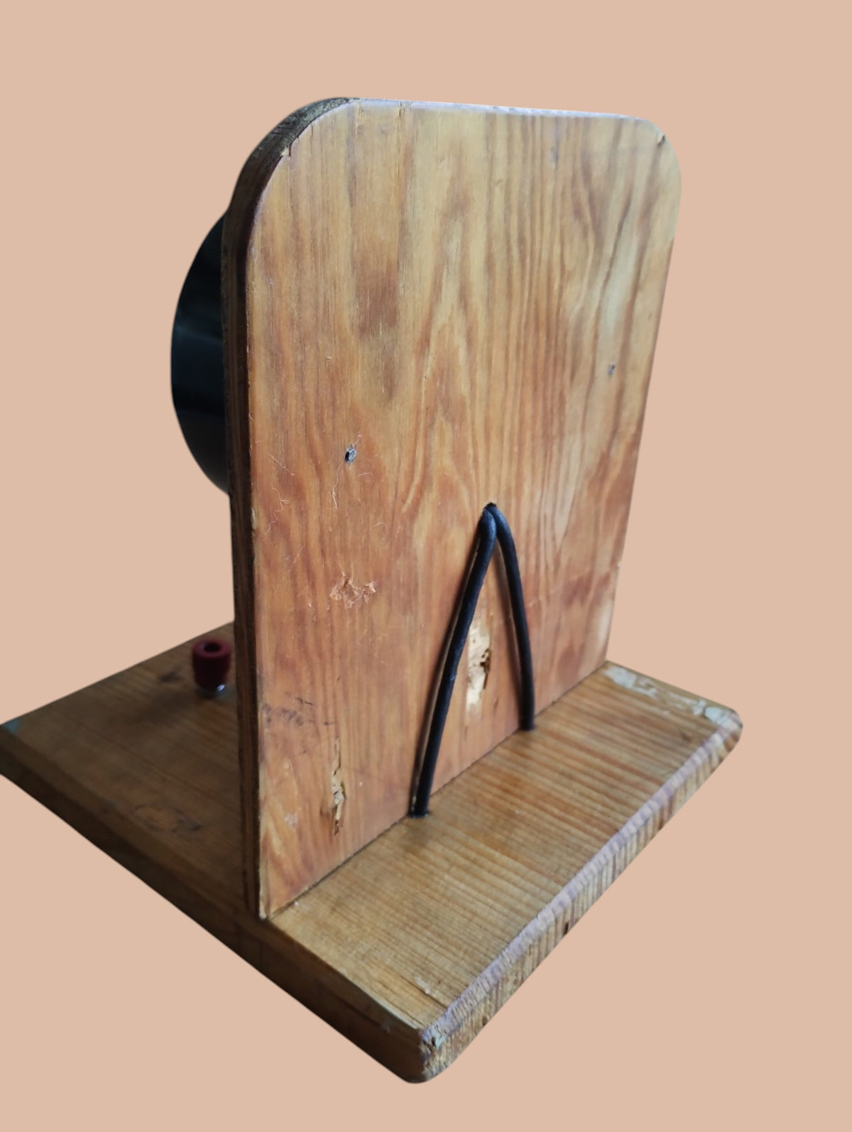 Rear view of the vintage voltmeter's wooden stand, showing the black cable and wear to the wood.
