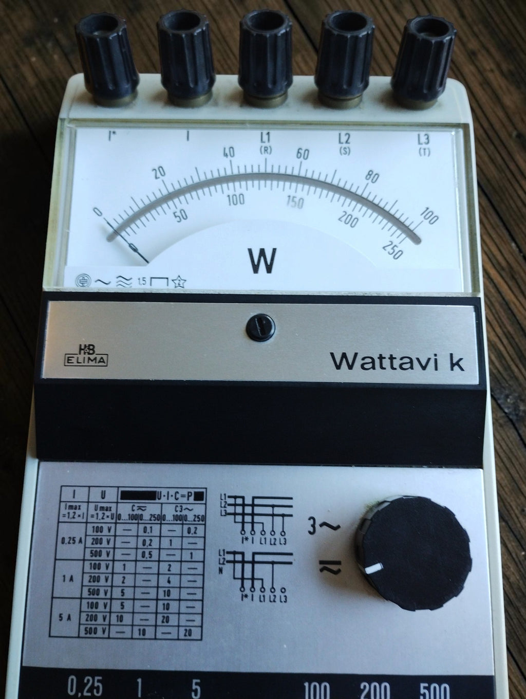 Close-up of the H&B Elima Wattavi k wattmeter showing the analog scale, five terminals, range table and connection diagrams
