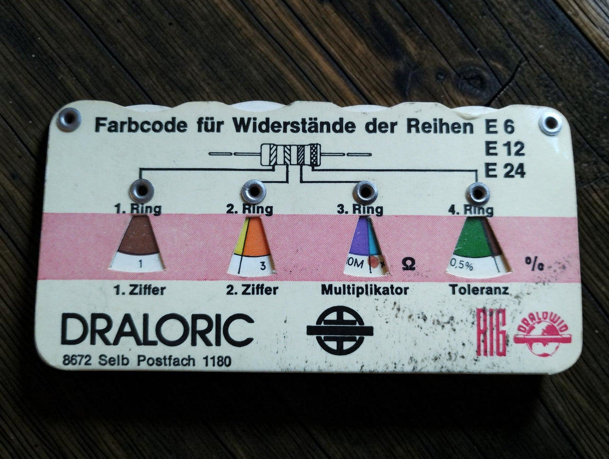 White and pink vintage Draloric resistor color-code calculator for E6, E12 and E24 series with visible age-related wear
