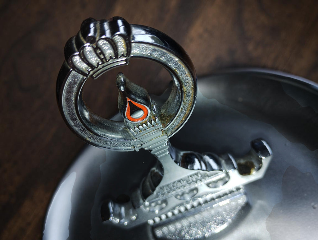 Close-up of the crown and orange flame motif on the central handle of the vintage Vitol Rotterdam pipe ashtray
