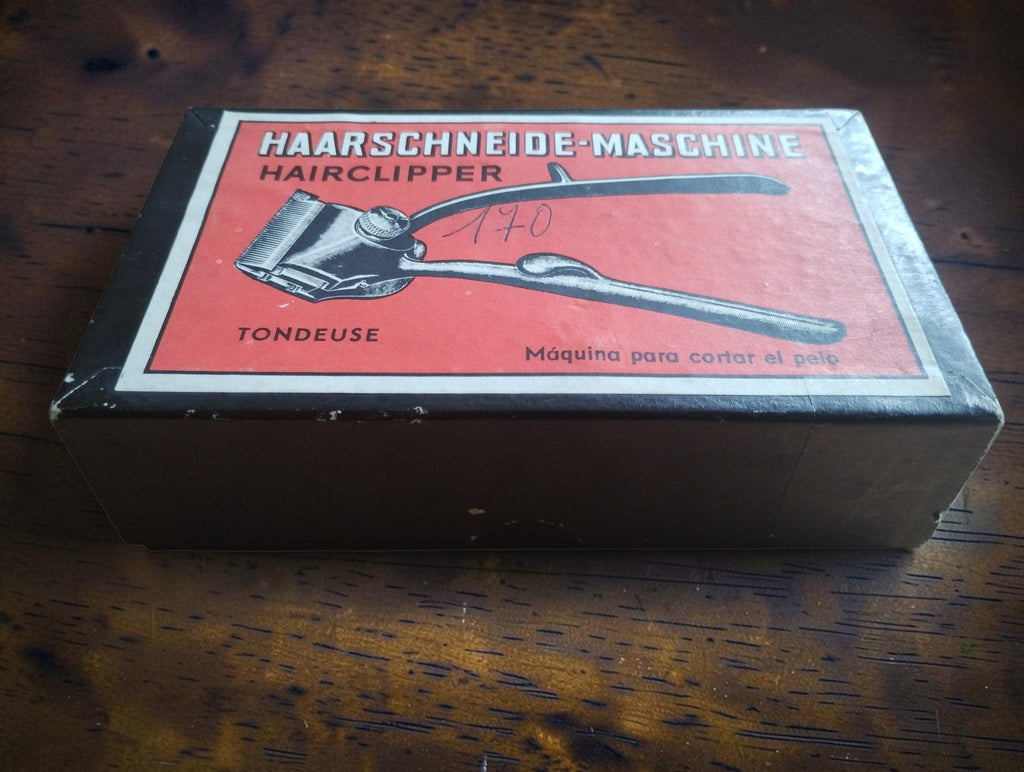 Original hair clipper box with red illustrated label and multilingual lettering
