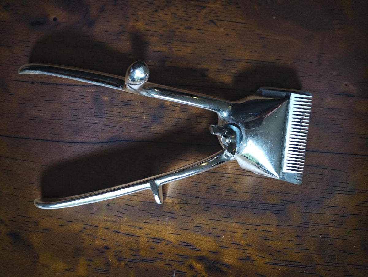 Vintage Éclair manual hair clipper with polished metal handles and toothed cutting head

