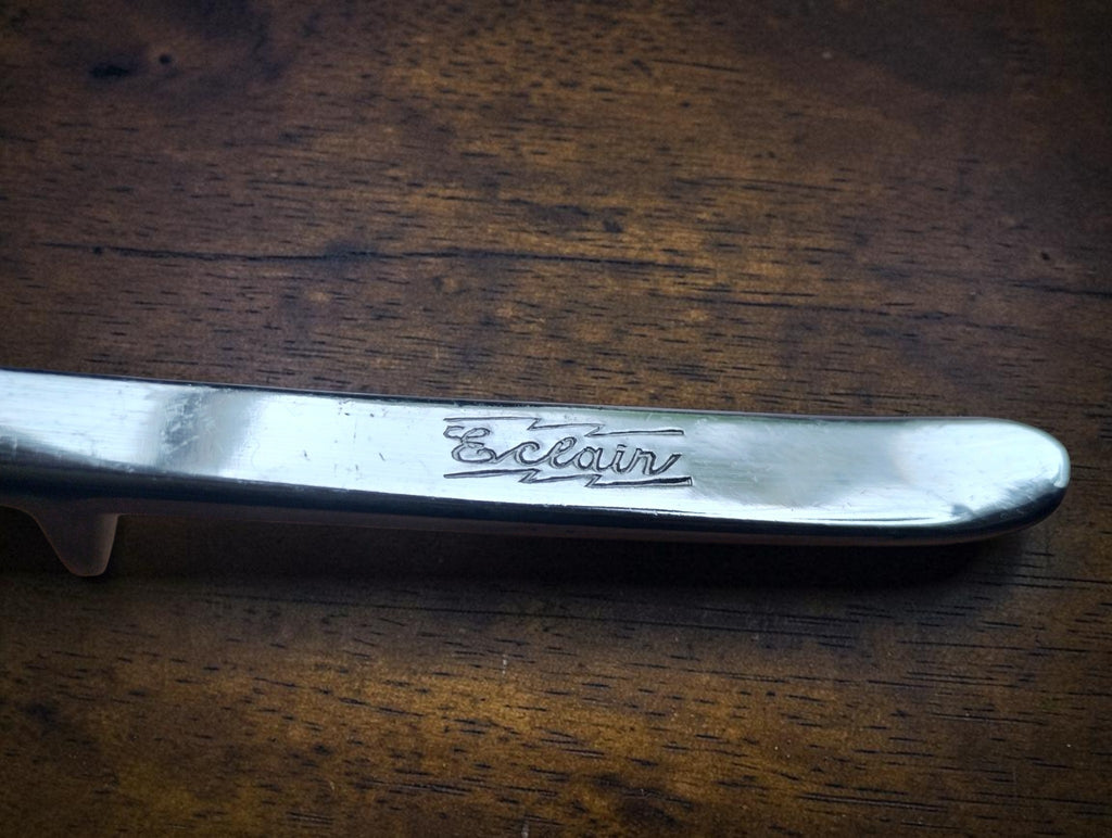 Close-up of the Éclair maker's mark engraved on the metal hair clipper handle
