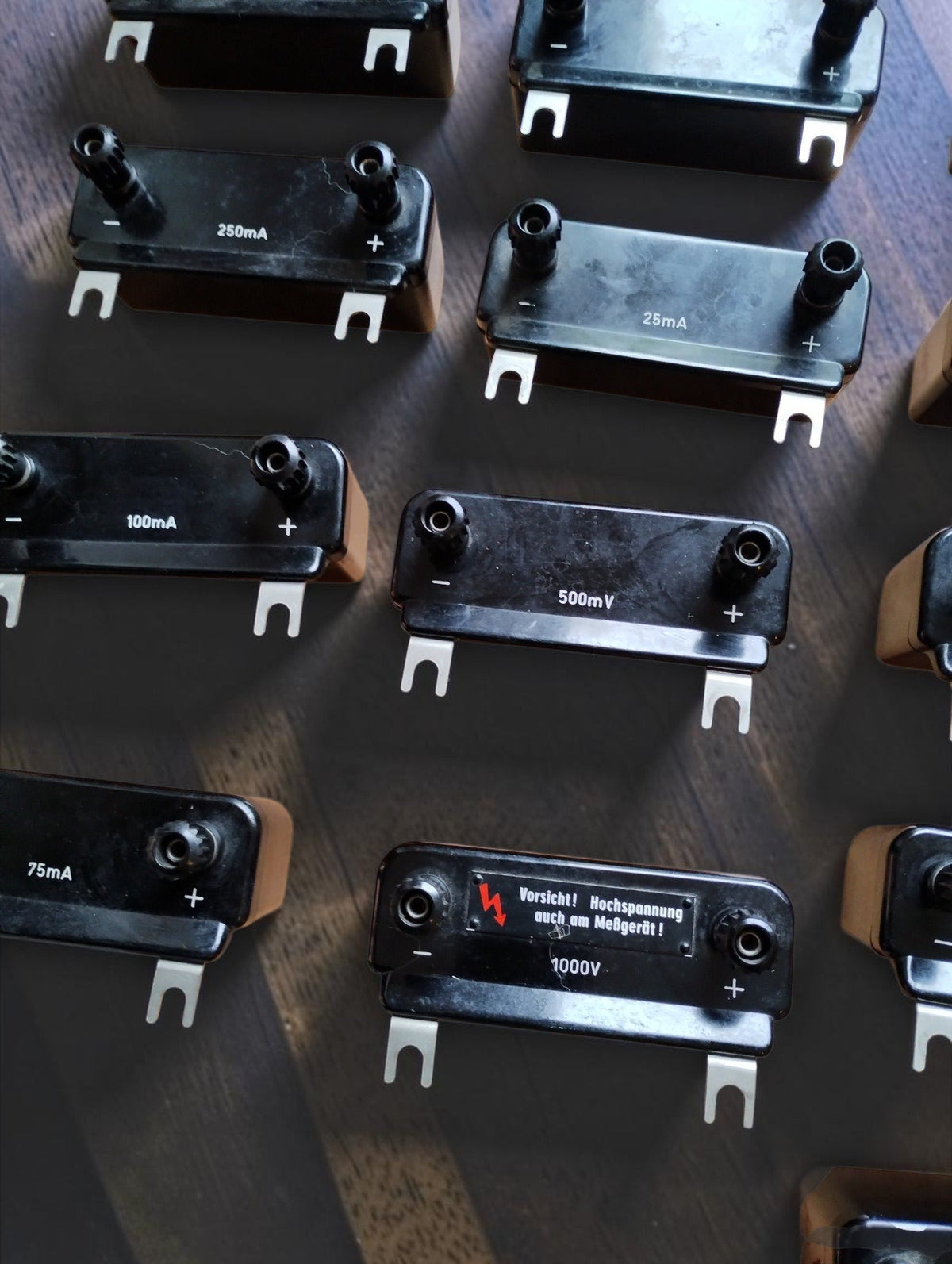 Gossen measuring range modules showing current and voltage markings, including a 1000 V multiplier with a red lightning warning label
