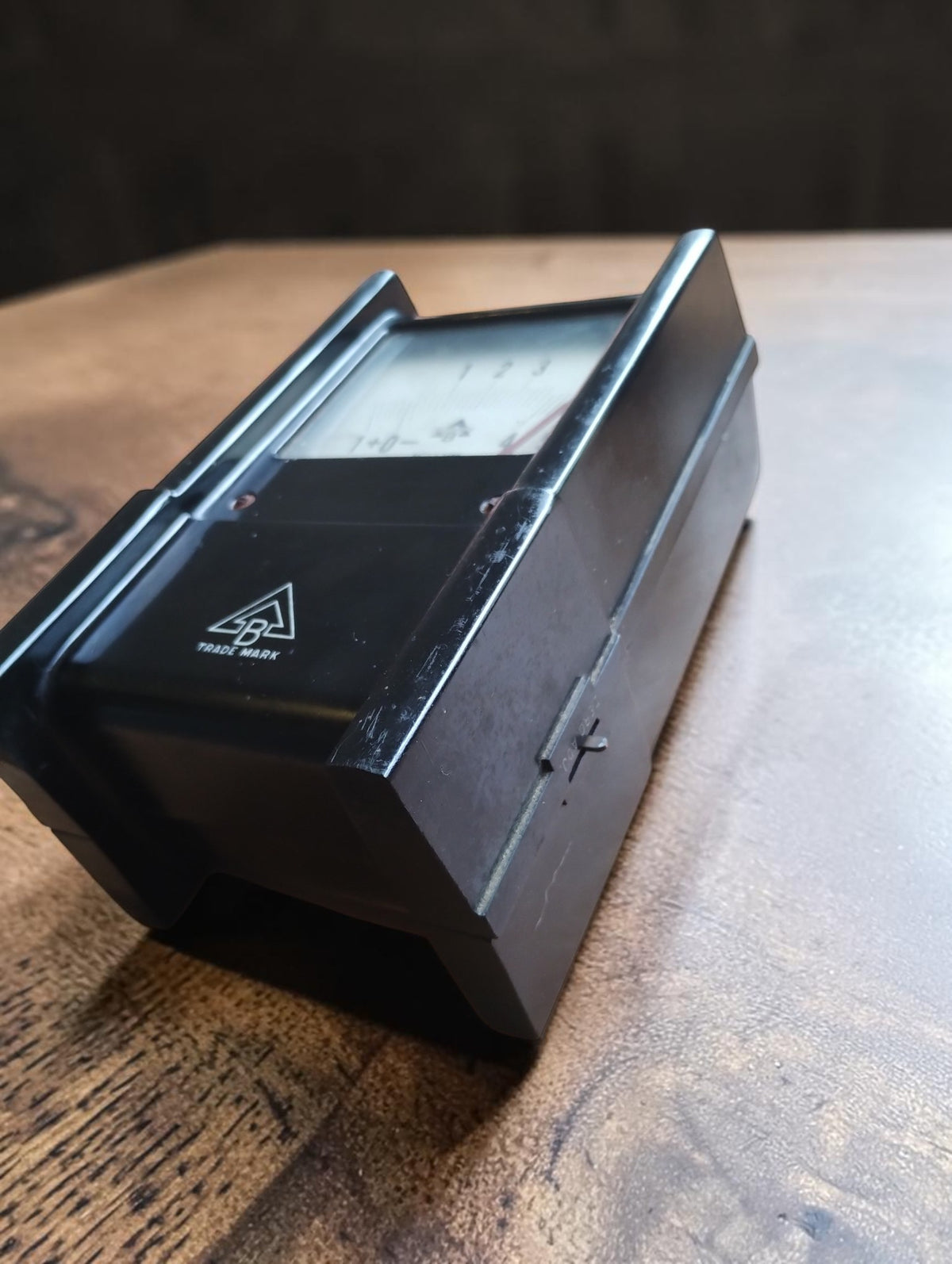 Side view of the Bacharach Model MZF pressure gauge showing the raised housing edges, recessed dial and scratches to the black finish.
