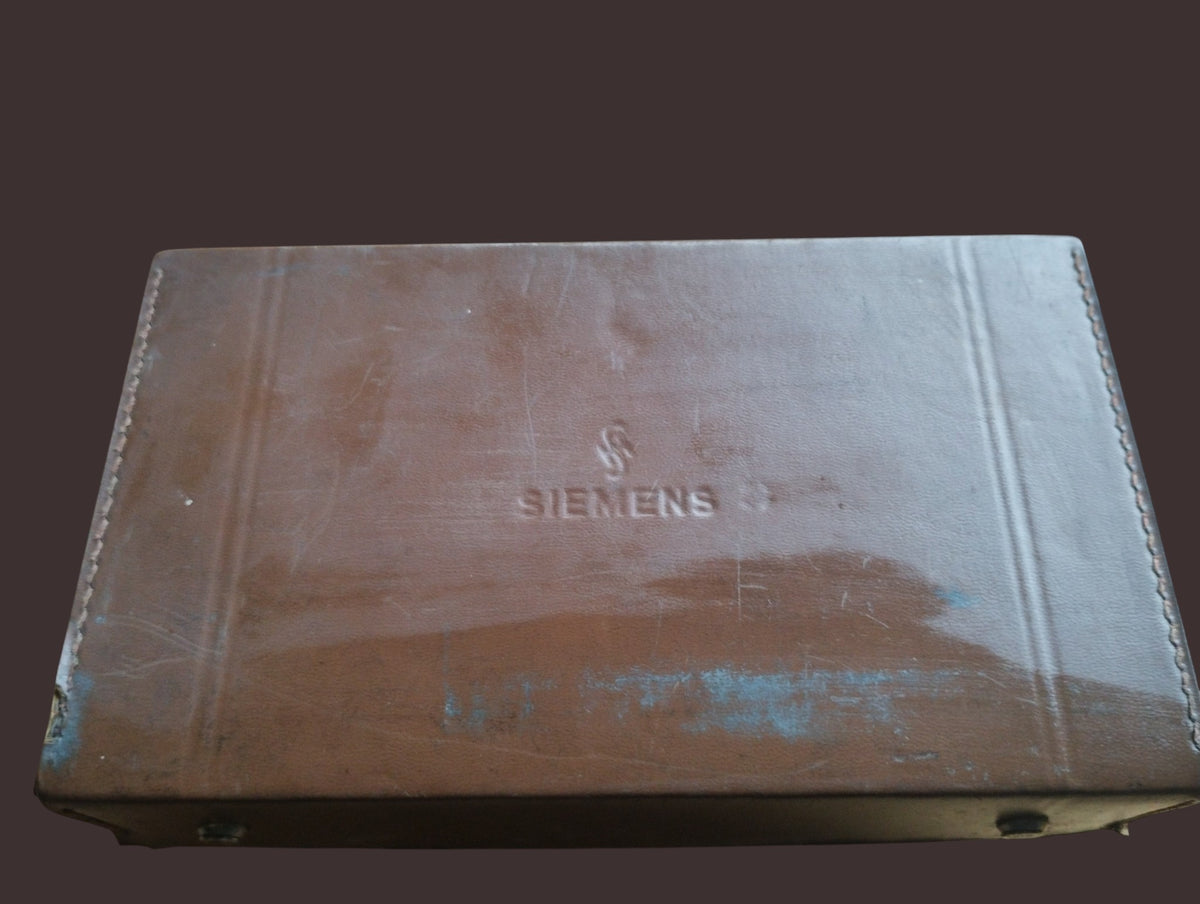 Closed brown Siemens carrying case with embossed branding and visible surface wear.
