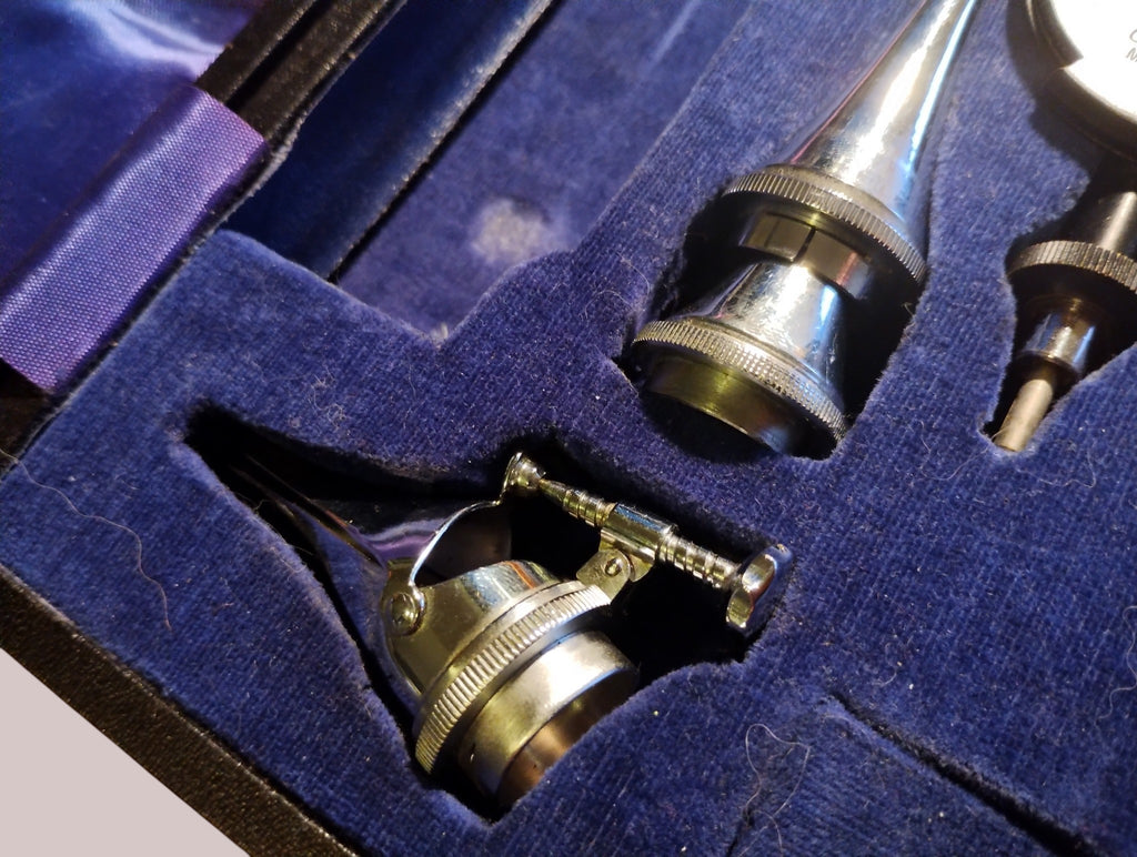 Close-up of a hinged metal attachment and conical instrument in the blue-lined Gowllands case
