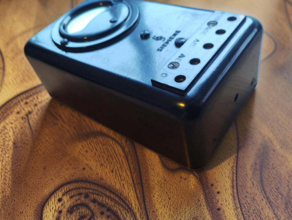 Angled view of the Siemens & Halske vintage voltmeter showing its black housing, raised dial and voltage terminals
