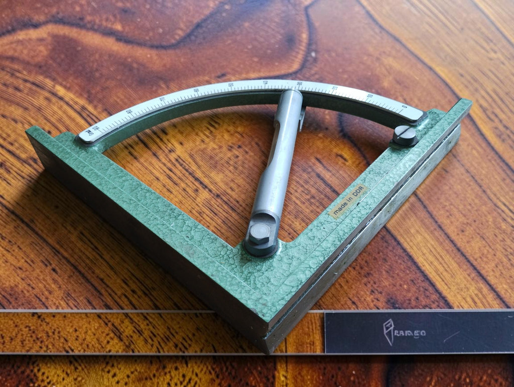 East German mechanical inclinometer with adjustable spirit level, curved degree scale and green hammer-finish frame
