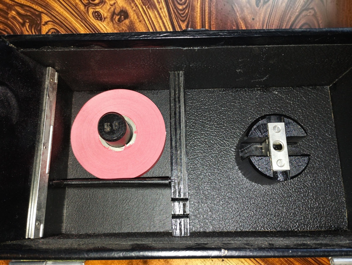 Storage compartment of the Siemens pulse recorder case with a spare red paper roll and spool holder.
