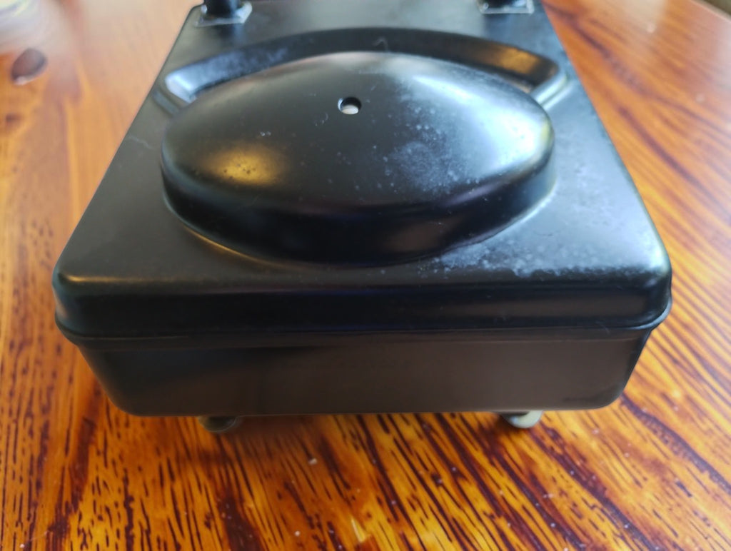 Low-angle view of the Siemens & Halske microammeter showing the raised black cover and Bakelite case with signs of age.

