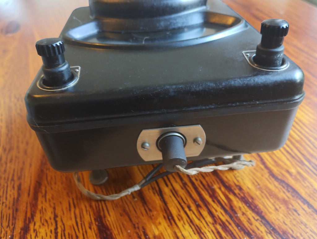Terminal-side view of the Siemens & Halske microammeter showing two binding posts, a central knob and an attached cord.
