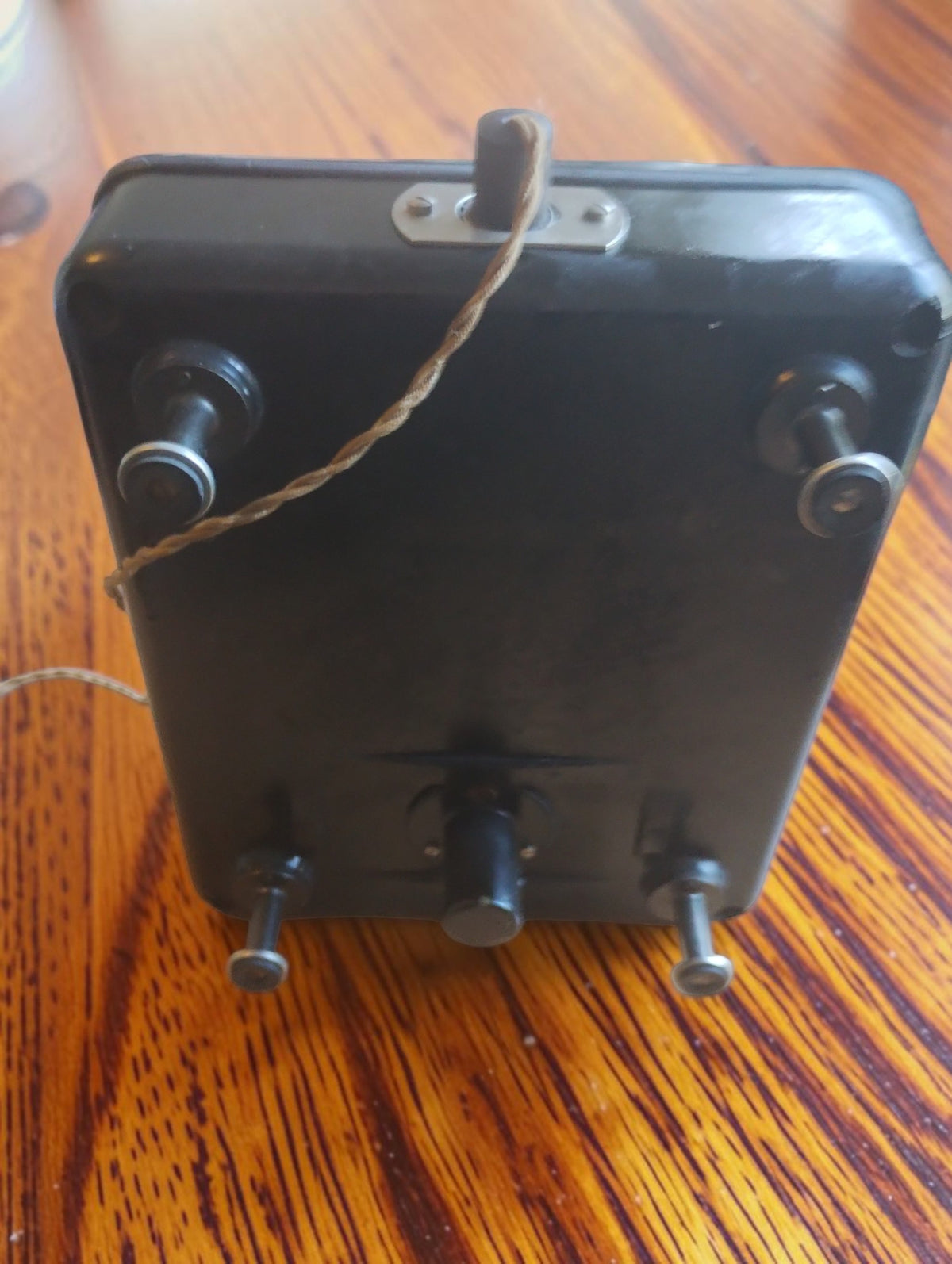 Underside of the Siemens & Halske vintage microammeter showing four feet, the black base and an attached cord.

