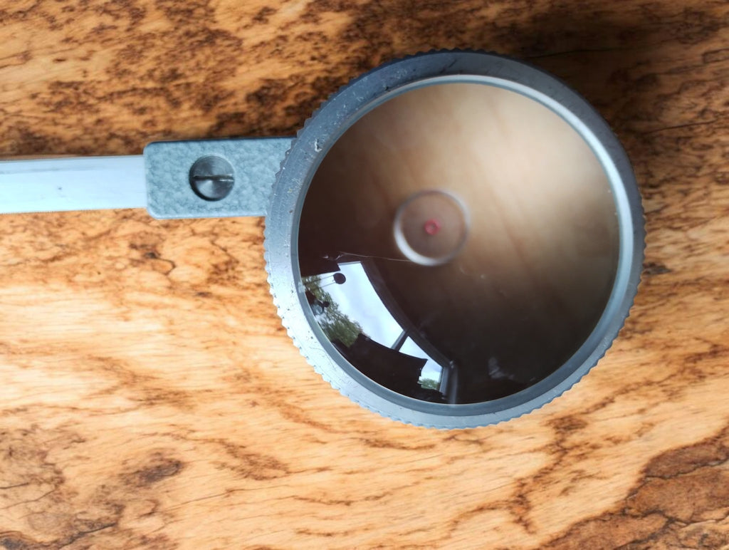 Close-up of the A. OTT planimeter tracing magnifier with central reference point and metal arm

