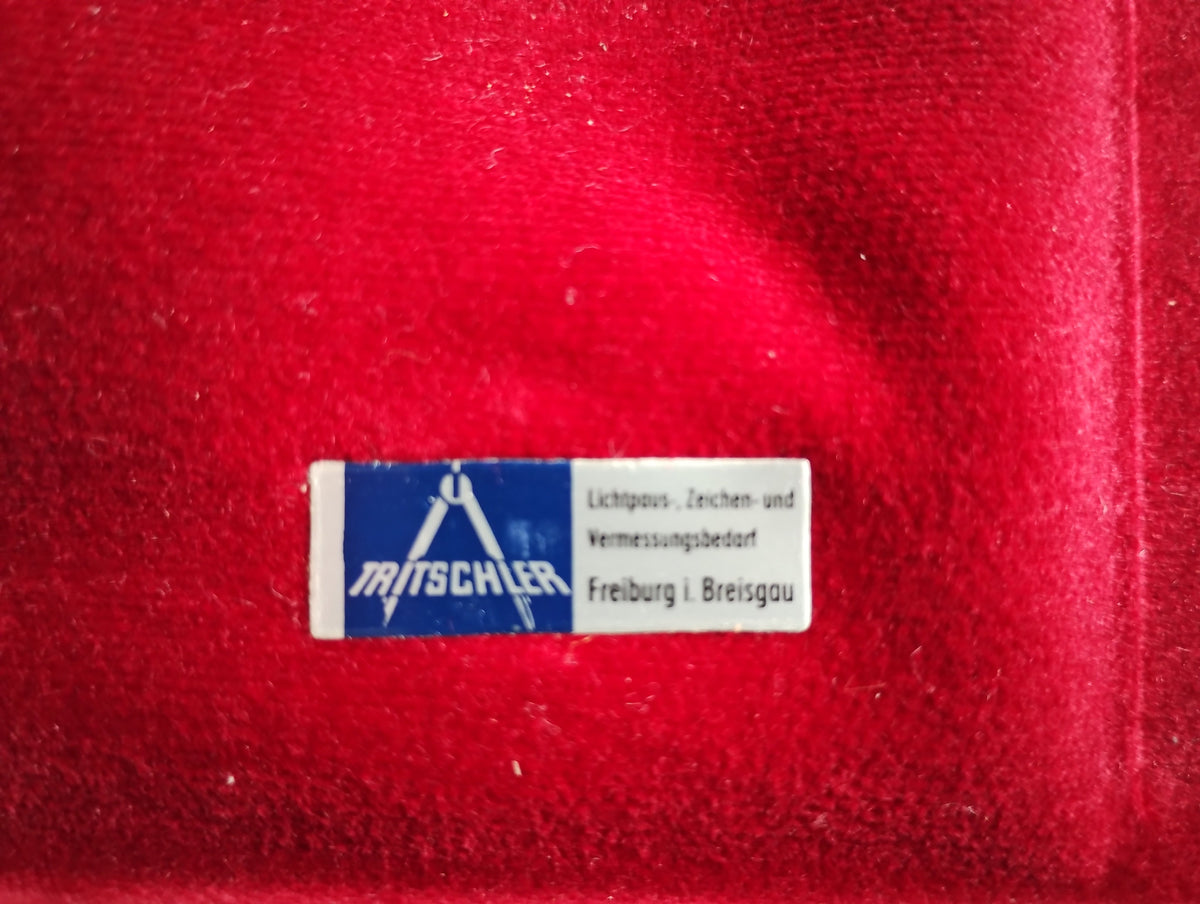 Supplier label inside the red-lined lid of the A. OTT Kempten planimeter case
