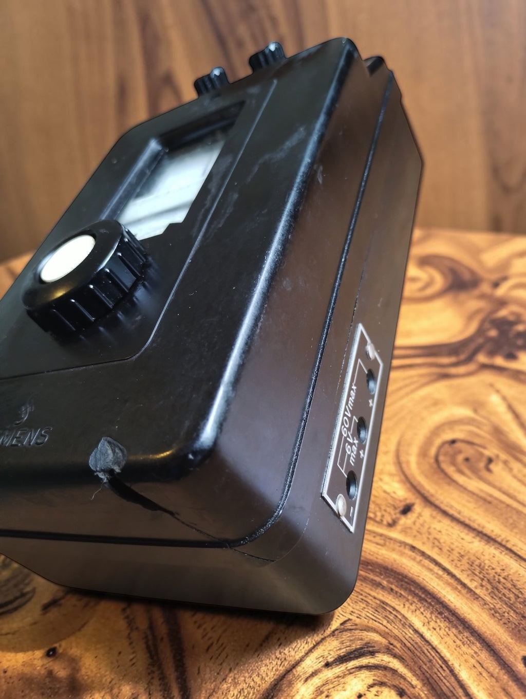 Angled view of the Siemens Bakelite resistance meter showing the side connections and chipped front corner

