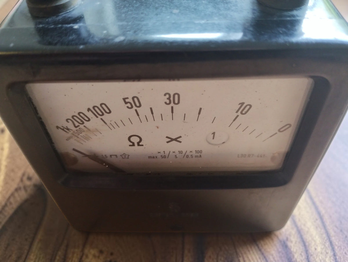 Close-up of the Siemens ohmmeter dial showing the curved resistance scale, ohm symbol, and range markings.
