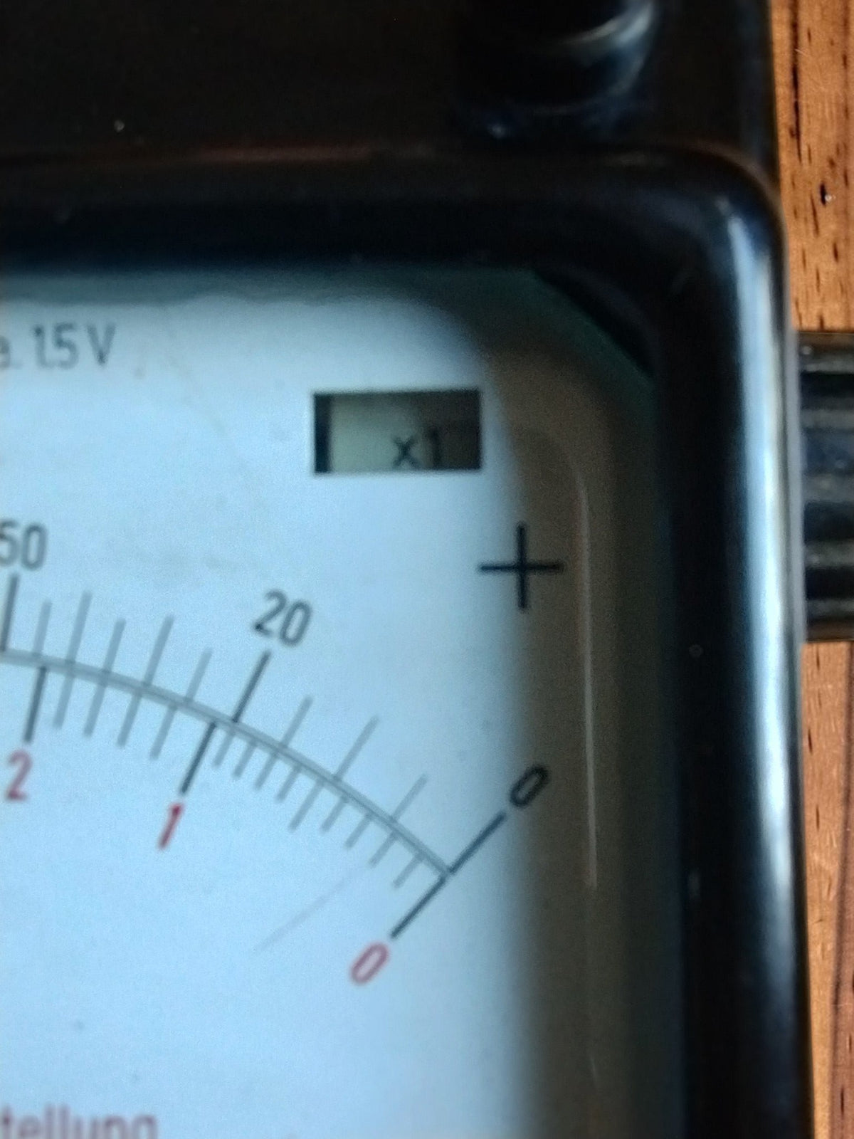 Close-up of the Gossen insulation tester dial showing the scale selector window and positive terminal marking
