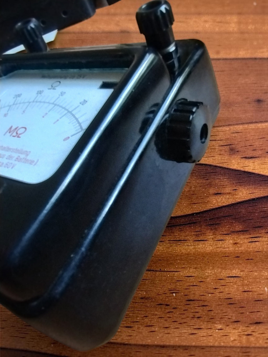 Side view of the vintage Gossen insulation tester with a ribbed adjustment knob and upper screw terminal
