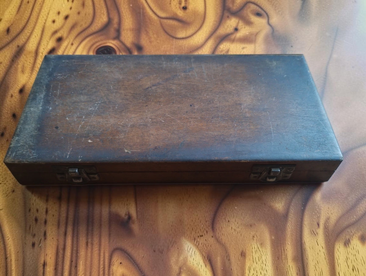 Closed wooden storage case for the P. Roch micrometer, showing surface wear and two metal clasps
