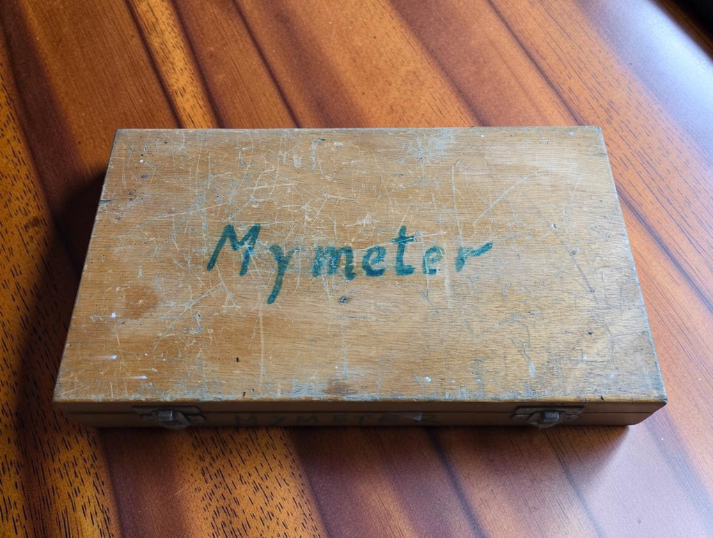 Closed wooden storage case with handwritten Mymeter name and visible signs of age and use.


