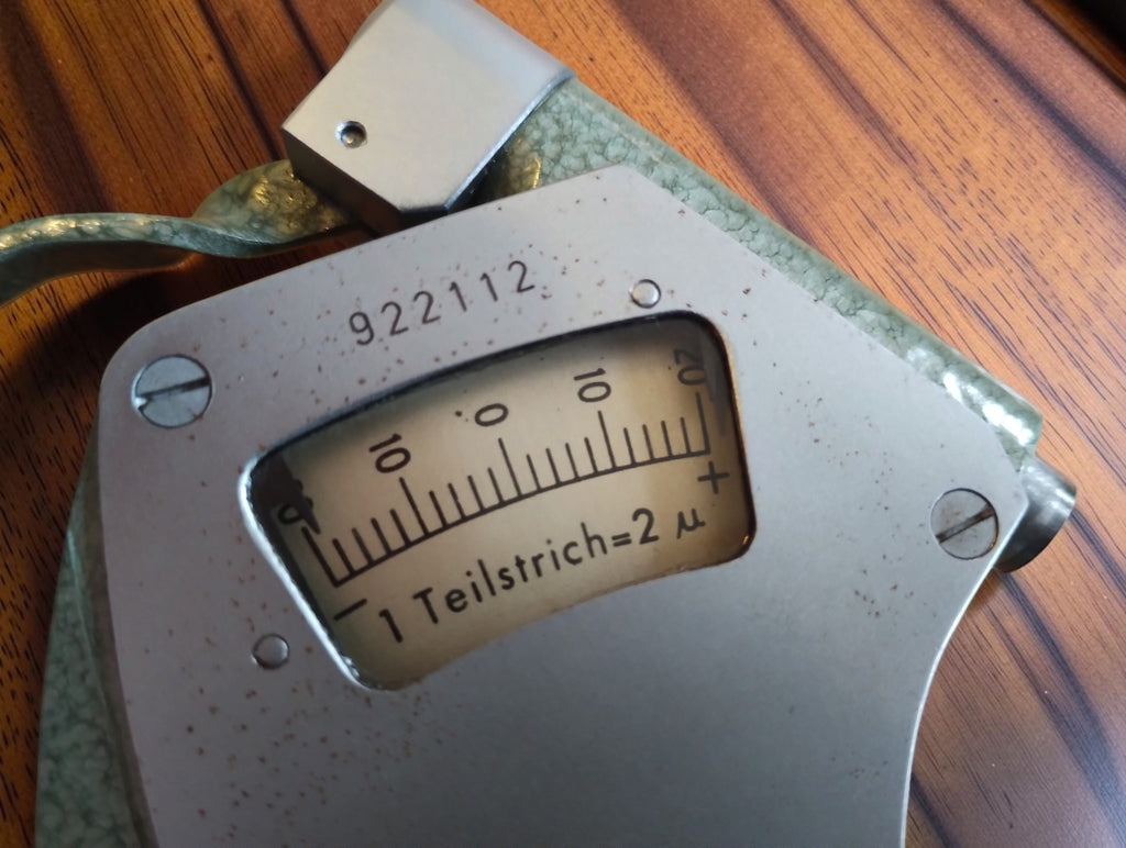 Close-up of the Mymeter indicator scale marked 1 Teilstrich = 2 µ and instrument number 922112.
