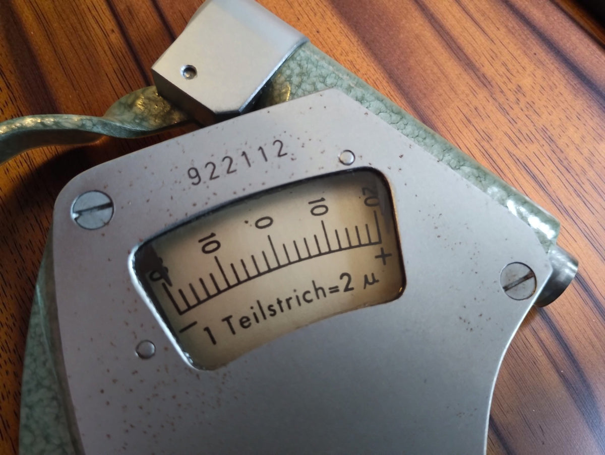 Close-up of the Mymeter indicator scale marked 1 Teilstrich = 2 µ and instrument number 922112.
