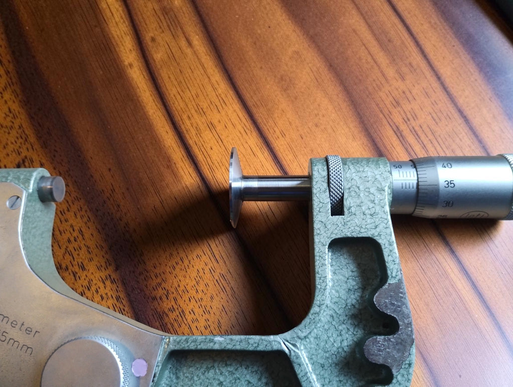 Close-up of the Mymeter measuring spindle, disc-shaped contact and graduated micrometer thimble.
