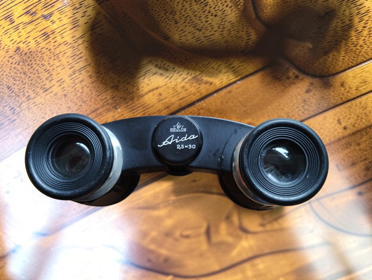 Close-up of vintage Aida opera glasses showing the eyepieces and 2.5 × 30 model marking
