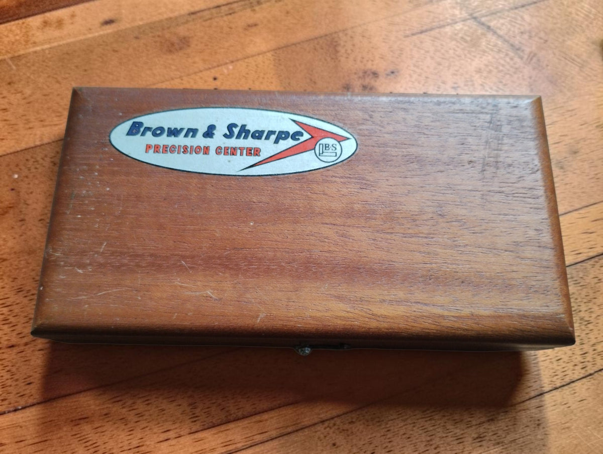 Closed wooden micrometer case with Brown & Sharpe Precision Center logo and visible vintage wear
