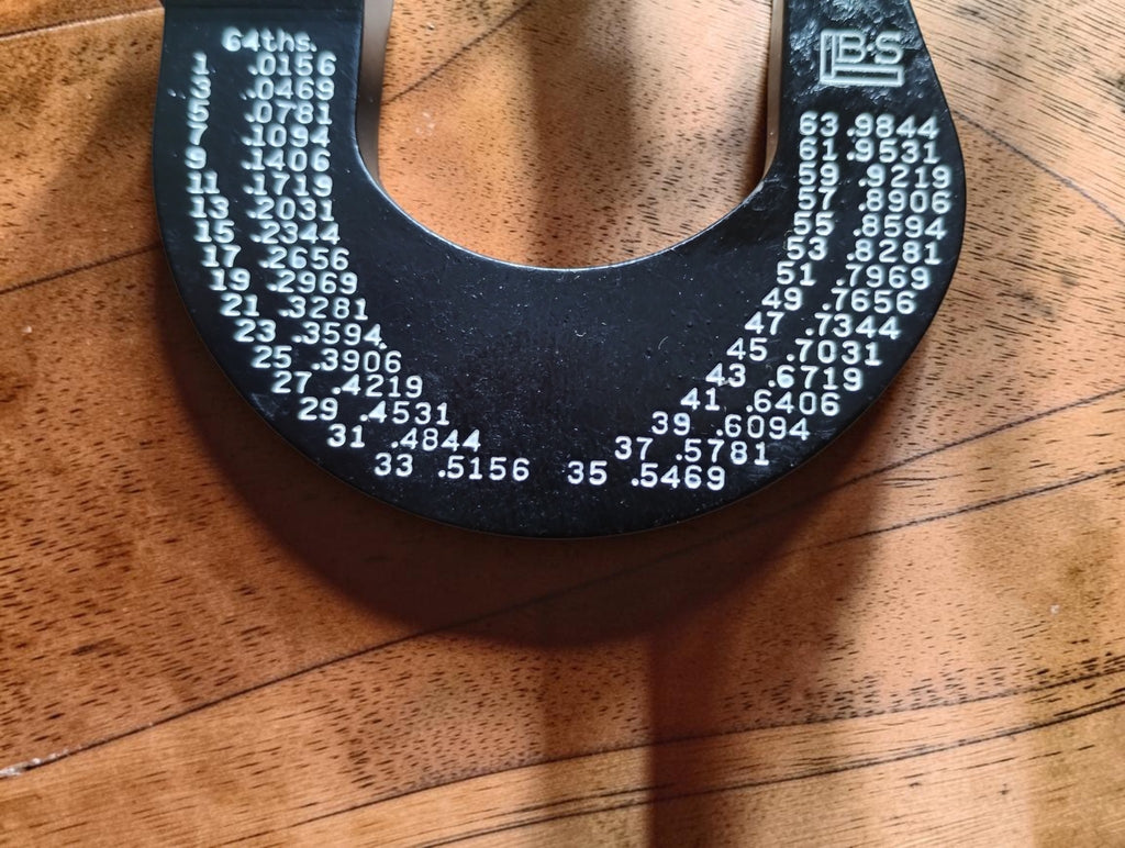 Close-up of the fractional inch conversion chart and B&S logo on the Brown & Sharpe No. 10 micrometer frame
